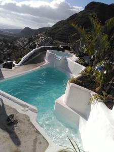 una piscina en medio de una montaña en Vilna House with private pool, jacuzzi and garden -Optional pool and jacuzzi heating, en Agaete