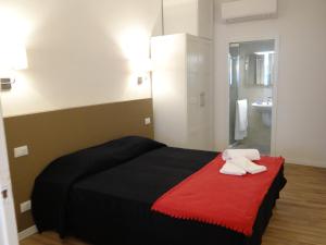 um quarto com uma cama preta e um cobertor vermelho em Palazzo Boldù - Ca'Arlecchino em Veneza