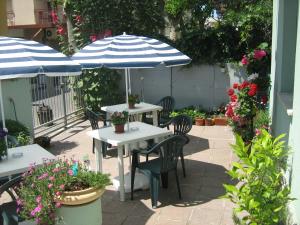 - deux tables et chaises avec parasols sur la terrasse dans l'établissement Sirenapop Concept B&b, à Rimini