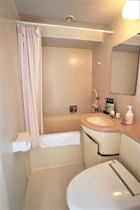 un piccolo bagno con servizi igienici e lavandino di Neyagawa Trend Hotel a Neyagawa