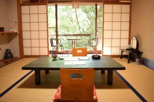 um quarto com uma mesa e cadeiras e uma janela em Yunominesou em Hongu