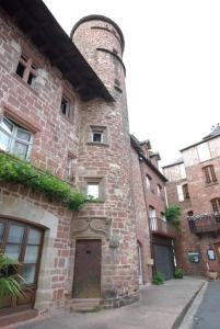 ein altes Backsteingebäude mit einer Seitentür in der Unterkunft LogisHotels Le Relais du Quercy in Meyssac