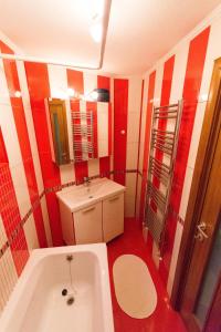 ブカレストにあるルーフトップ テラス アパートメントの赤と白のバスルーム(バスタブ、シンク付)