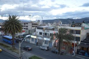 une ville avec des voitures et des palmiers dans une rue dans l'établissement Hostal Alborada Riobamba, à Riobamba