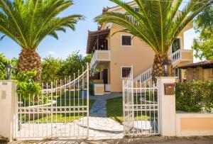 a gate in front of a house with palm trees at Sea Side Apartments & Studios-Renovated in Tsilivi