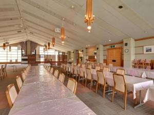 a banquet hall with tables and chairs and a pool of water at Oze Iwakura Resort Hotel in Katashina