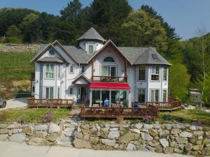 a large white house with people sitting on the porch at Happy Dream Pension in Pyeongchang
