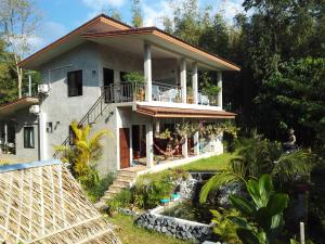 a house with a pond in front of it at Nananuira Apartment and Room in Khao Lak