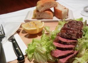 einen Teller mit Fleisch, Salat und Brot in der Unterkunft Raintree Lodge in Port Moresby