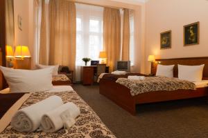 een hotelkamer met 2 bedden en handdoeken erop bij Hotel Arche in Berlijn