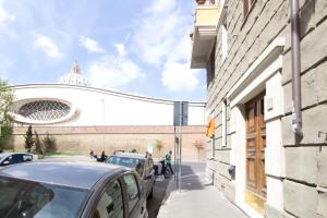 une rue avec des voitures garées sur le côté d'un bâtiment dans l'établissement Lunaria Suites Rome Vaticano, à Rome