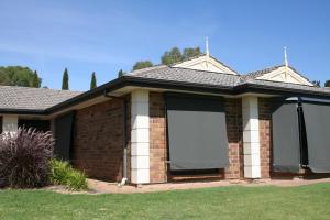 a house with two roller shades on the front of it at Jacaranda Homestay in Gawler