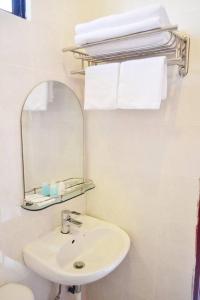 a white bathroom with a sink and a mirror at Skyville Zen Resort,Kundasang in Kundasang