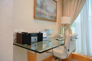a glass desk with a microwave and a chair in a room at Regal Hongkong Hotel in Hong Kong
