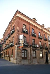 un gran edificio de ladrillo rojo con un cartel. en Hotel La Posada Regia, en León