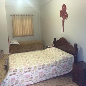 a bedroom with a bed and a cross on the wall at Sobrado Itapoá in Itapoa