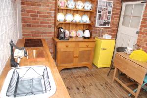 a kitchen with a sink and a brick wall at Hillside Cottage Berrima in Berrima