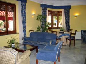 sala de estar con muebles azules, mesa y sillas en Hotel Paris en Lanjarón