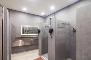 a bathroom with a shower stall with a mirror at Norn Yaowarat Hotel in Bangkok