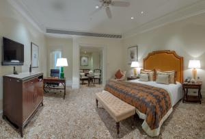 a hotel room with a large bed and a television at The Taj Mahal Palace, Mumbai in Mumbai