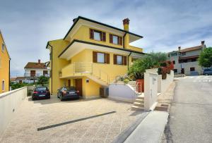 una casa amarilla con un coche aparcado en una entrada en Villa NiNa B&B Rovinj, en Rovinj