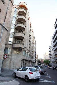 un coche blanco estacionado frente a un edificio en Hostal Santel San Marcos, en Salamanca