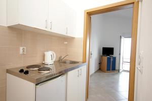 a kitchen with a sink and a stove top oven at Apartments Vila Dusan in Sutomore