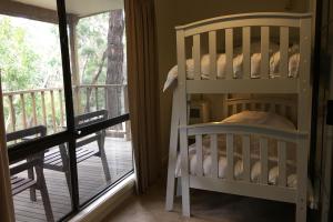 a bedroom with two bunk beds and a balcony at The Ledge Holiday House in Halls Gap