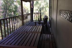 een veranda met een bank aan de zijkant van een gebouw bij The Ledge Holiday House in Halls Gap