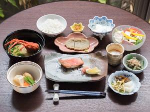 a table with bowls and plates of food on it at Hotel Hagoromo in Shizuoka