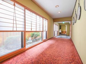 an empty hallway with large windows and a red carpet at Hotel Hagoromo in Shizuoka