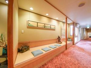 a room with a long bench with three blue pillows at Hotel Hagoromo in Shizuoka
