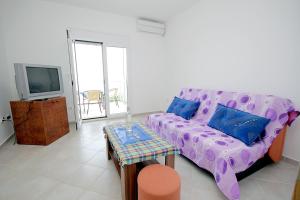 a living room with a purple couch and a table at Apartments Vila Dusan in Sutomore