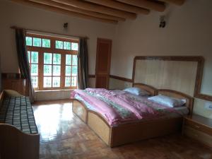 a bedroom with a bed and a large window at Gangs-Shun Homestay in Leh