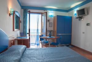 ein Hotelzimmer mit einem Bett, einem Tisch und einem Fenster in der Unterkunft Sogni Nel Blu in Ustica
