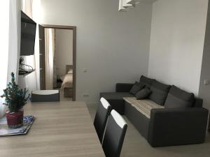 een woonkamer met een bank en een tafel bij Taikos Apartmentai 2 in Druskininkai