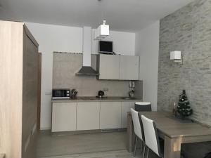 a kitchen with a table and a dining room at Taikos Apartmentai 2 in Druskininkai +6 photos