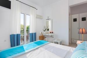 a bedroom with a bed and a window at Iris Beach Hotel in Monemvasia