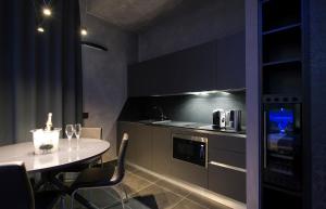 
a kitchen with a table, chairs and a microwave at Mia Aparthotel in Milan
