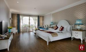 ein Schlafzimmer mit einem großen weißen Bett und einem Sofa in der Unterkunft Silk Queen Grand Hotel in Hanoi