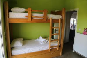 2 Etagenbetten in einem Zimmer mit grüner Wand in der Unterkunft Konstantinos Luxury Apartment in Keramotí