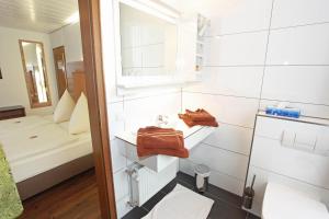 a bathroom with a sink and a toilet in a room at Hotel Hubertus in Ennigerloh