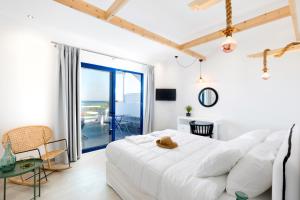 a white bedroom with a large bed and a table at Dimitra Boutique Rooms in Faliraki