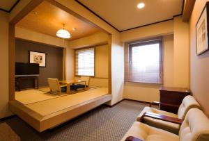 um quarto com uma sala de estar com uma mesa e cadeiras em Chisun Hotel Utsunomiya em Utsunomiya