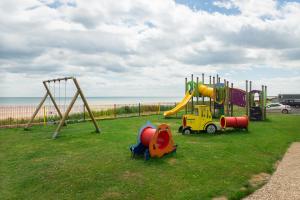 a playground in a park next to the beach at Pebbles 144 South Shore 2 bed chalet 2 dog friendly, sleeps 4 in Bridlington