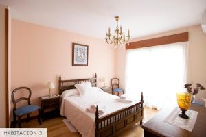 1 dormitorio con cama y lámpara de araña en CasaMiranda30, en Salamanca