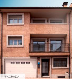 a brick building with a garage and a balcony at CasaMiranda30 in Salamanca