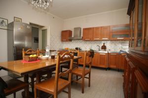 a kitchen with a wooden table and wooden chairs at B&B DE CAROL in Gramignazzo