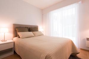 a white bedroom with a bed and a window at Riviera Home in Mandelieu-La Napoule +16 photos