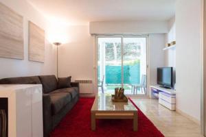 a living room with a couch and a tv at Riviera Home in Mandelieu-La Napoule